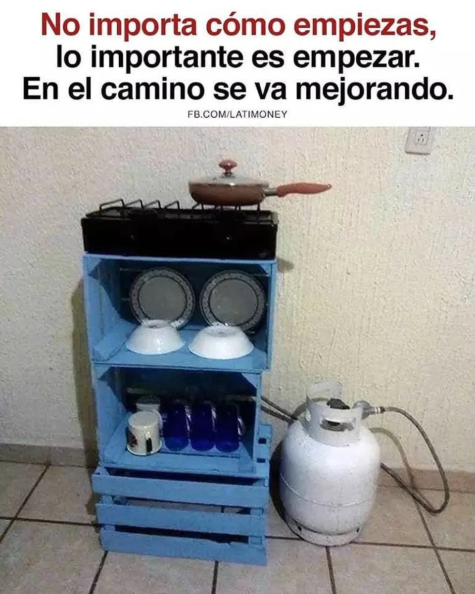 Una cocina improvisada con una garrafa de gas, un hornillo, platos, vasos y una sartén. Todo ello colocado sobre una estantería de madera pintada de color azul.